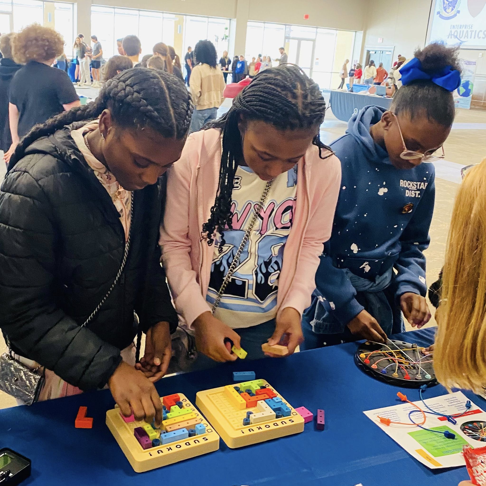 Two girls arranging colored blocks on a grid.